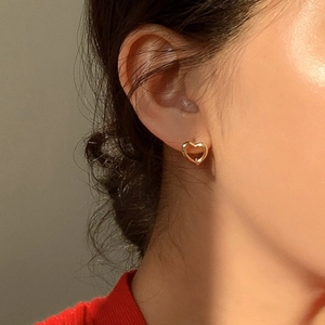 Boucles d'oreilles créoles cœur doré minimalistes portées pour un look quotidien chic