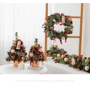 Close-up of Christmas wreaths and mini trees with gold ornaments and Merry Christmas signs