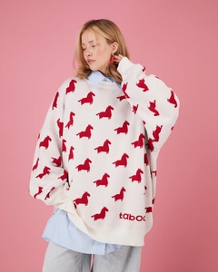 Détail du motif jacquard poney rouge et du logo taboo tricoté sur un pull blanc oversize