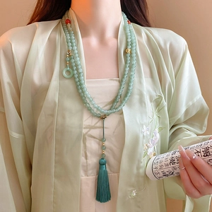 Detail of emerald green multi-layer beaded necklace with elegant green silk tassels