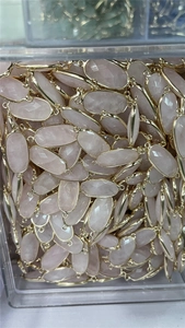 Macro shot of faceted pink crystal connectors with double-loop gold plated frames for DIY jewelry