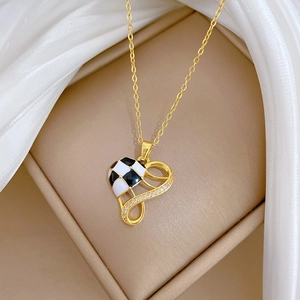 Detail view of heart necklace with checkerboard enamel and cubic zirconia in a jewelry box