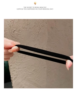 Detail shot showing hands stretching a thick, high-elasticity black hair tie for durability