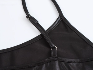 Detail of adjustable thin shoulder strap with metal buckle on a black sequin dress
