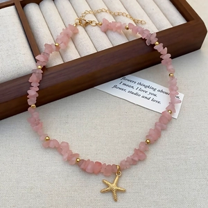 Detail of pink crystal beads and golden starfish pendant necklace with adjustable chain