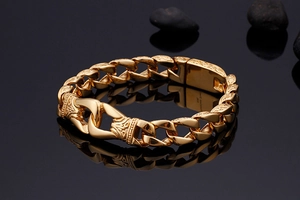 Macro shot of vintage gold chain bracelet with engraved textures and shield clasp detail
