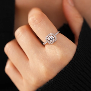 Detailed view of silver flower open ring with sparkling zircon stones worn on finger