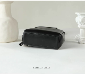 Detail view of black leather chest bag with silver D-ring and neat stitching finish