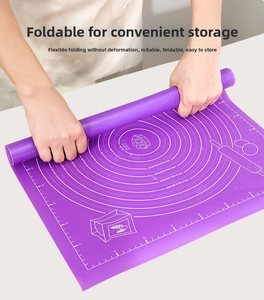 Flexible purple silicone baking mat with measurements being rolled up for storage