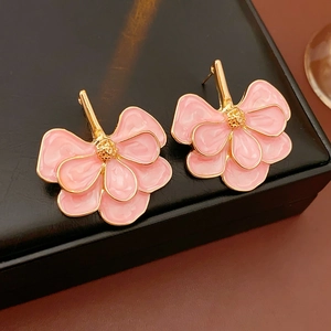 Detail of pink and gold ginkgo leaf flower earrings on black leather jewelry box