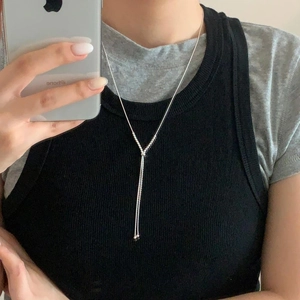 Mirror selfie showing a silver Y-shaped beaded sweater necklace on a person wearing black