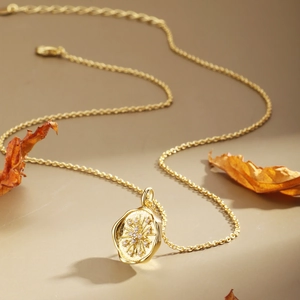 Vintage gold coin necklace with starburst sunburst pattern and white zircon stones