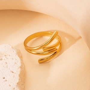 Close-up of golden spiral multi-layer ring with polished finish on decorative rock