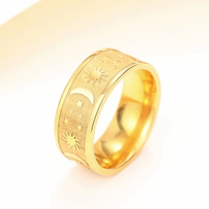 Macro detail of gold celestial ring with matte finish, moon and star patterns