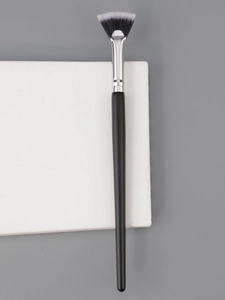 Detailed view of a fan-shaped makeup brush with soft bristles and a sleek black handle