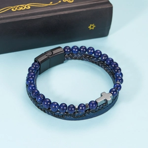 Detail of layered leather bracelet with blue natural stones and silver cross pendant