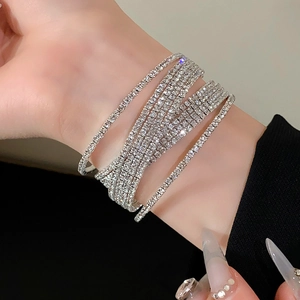 Detailopname van fonkelende zilveren meerlaagse strass armband om de pols
