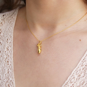 Dettaglio della collana con ciondolo scarpetta da ballo placcata oro 18K su modella