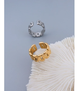 Detailed macro view of gold and silver watchband style chain rings on a coral texture