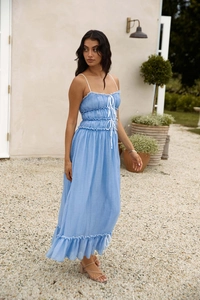 Détail de la robe d'été bleu ciel avec bustier smocké et petits nœuds blancs décoratifs