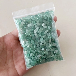 Close-up of polished green natural crystal stones in a transparent sealed plastic bag