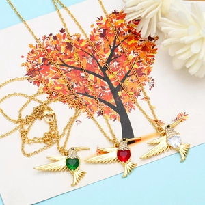 Detail of gold hummingbird necklaces with micro-set zircons and heart-shaped gemstones