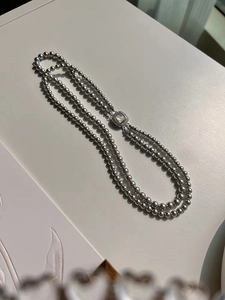 Macro detail of double-layer gray pearl necklace with square mother-of-pearl clasp