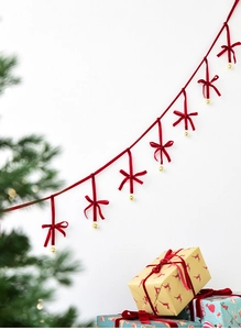 Detail of red velvet Christmas bow banner with gold bells on a festive background
