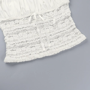 Detail of white lace texture and satin bow ribbon on a summer camisole top