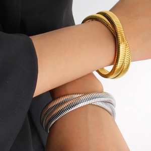 Close-up of flexible gold and silver snake bone bracelets on a model's wrist