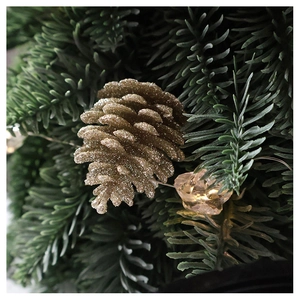 Detail of glittered champagne pine cone with LED crystal lights on pine needles