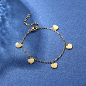Elegant gold chain bracelet with five heart pendants on a sparkling navy background