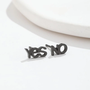 Close-up of black asymmetrical Yes and No letter stud earrings on white background