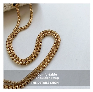 Detail of premium golden metal chain strap on a white tweed shoulder bag