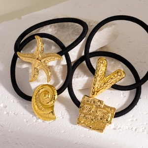 Golden starfish and shell metal pendants on elastic black hair ties set on stone