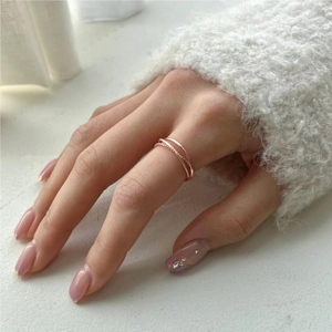 Rose gold multi-layer twisted rope ring shown on model finger in a lifestyle shot