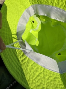 Detail of neon green sun hat featuring adjustable inner drawstring and white sweatband