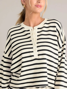 Detail view of striped long sleeve top with functional buttoned Henley neckline