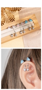 Detail of titanium cat ear cartilage studs with heart and star charms in multiple colors