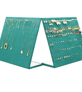 Macro shot of dark green velvet jewelry display stands for necklaces and earrings