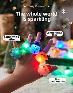 Close-up of LED Christmas glowing rings in reindeer, snowman and tree shapes on fingers