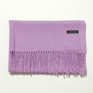 Detail shot of the purple cashmere scarf featuring soft texture and elegant tassel trim