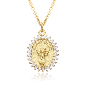 Macro shot of 18k gold plated Divino Nino medallion pendant with zircon stones