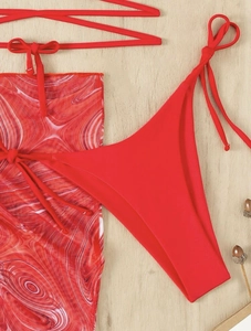 Detailed view of red tie-up bikini set with a matching red and white swirl print mesh skirt
