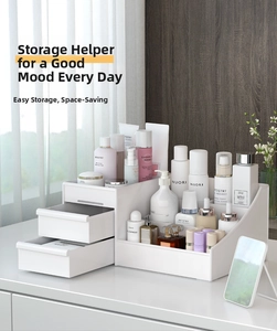 Close-up of a white desktop makeup organizer with two drawers and tiered compartments