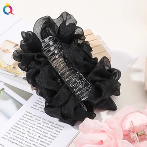 Detail of large black chiffon bow hair claw clip showing layered fabric texture and design