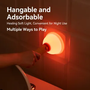 Portable wooden magnetic night light with warm orange glow attached to bathroom wall tiles