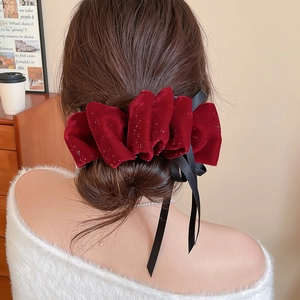 Détail d'un nœud papillon en velours rouge avec paillettes et longs rubans de satin noir