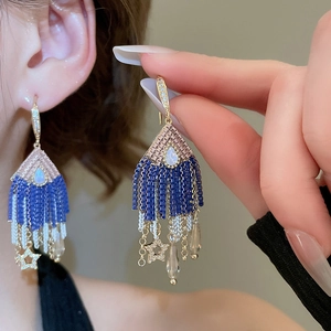 Detail of luxury teardrop star crystal tassel earrings with gold-plated zircon hooks