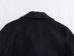 Detailed view of the rear collar and shoulder stitching on dark navy wool coat